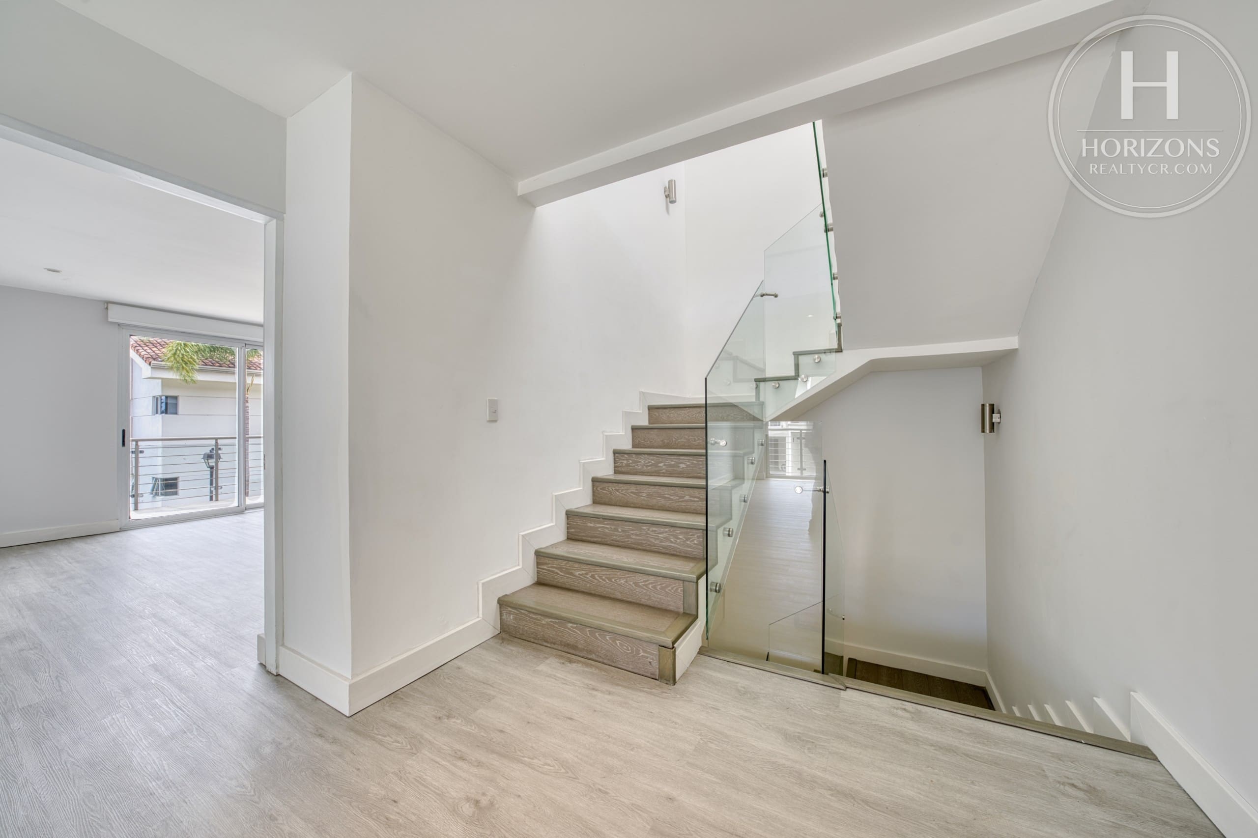 Escalera entre niveles con baranda de vidrio – Casa en Condominio Vistas de Escazú, San Rafael de Escazú | Horizons Realty