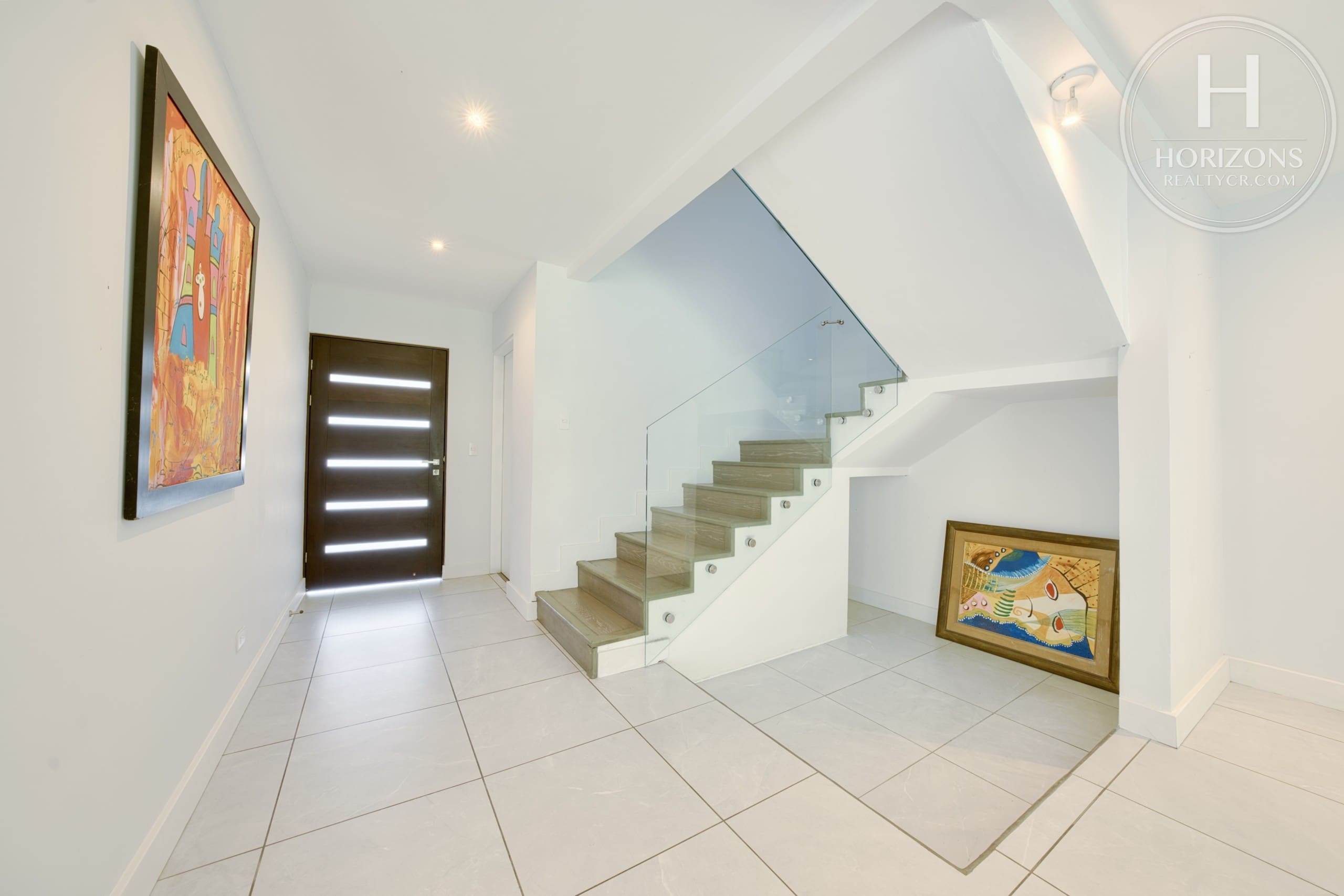 Recibidor y escalera con baranda de vidrio – Casa en Condominio Vistas de Escazú, San Rafael de Escazú | Horizons Realty