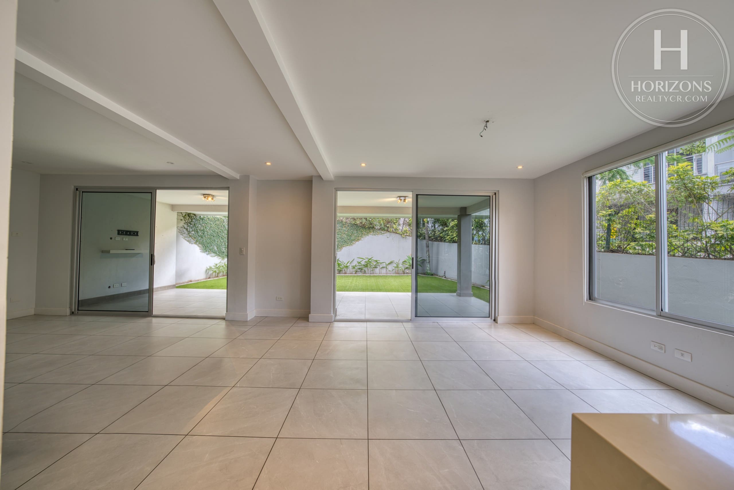 Sala y comedor con salida a la terraza y el patio – Casa en Condominio Vistas de Escazú, San Rafael de Escazú | Horizons Realty