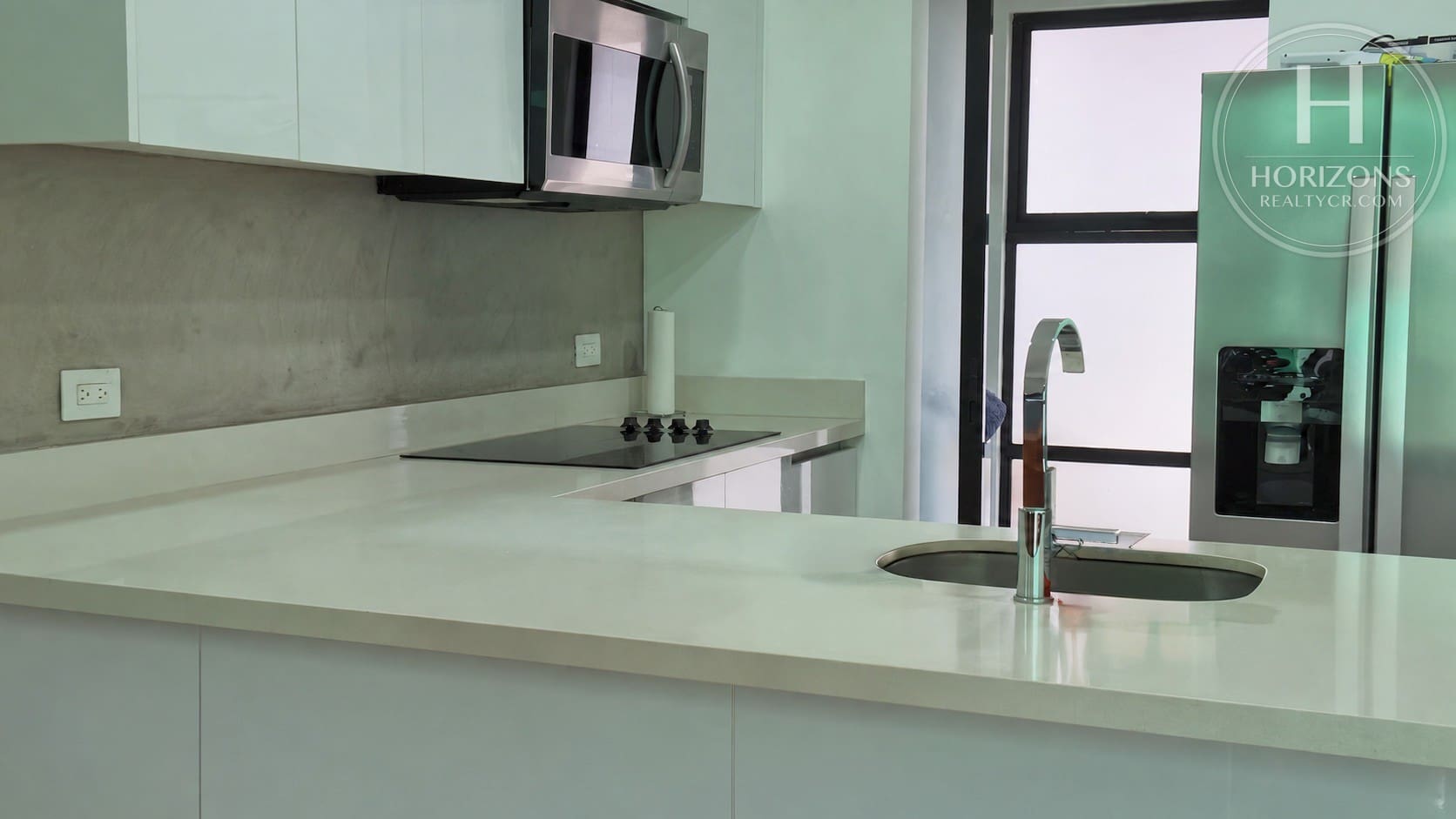 Cocina con plantilla de vitrocerámica y microondas – Casa en Condominio Bali, Guachipelín de Escazú | Horizons Realty