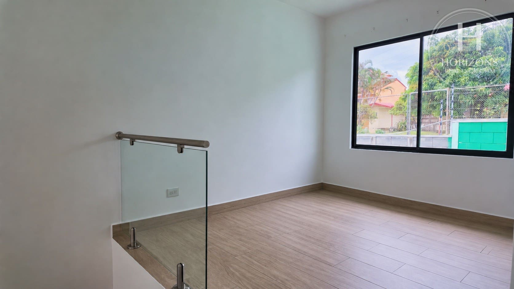 Sala de TV en el segundo nivel con baranda de vidrio – Casa en Condominio Bali, Guachipelín de Escazú | Horizons Realty
